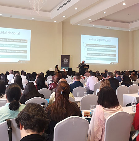 Foto de personas recibiendo capacitación en un salón de conferencias